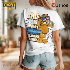 White tee with Garfield graphic! Text: THIS IS WHAT FREEDOM LOOKS LIKE! Cartoon cat wears USA flag sunglasses!