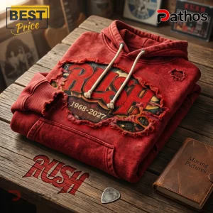 Distressed red pullover hoodie with a ripped graphic featuring the RUSH band logo and dates '1968-2027' in a vintage style!
