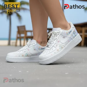 White sneakers with custom art of cartoon aliens Stitch and Angel, palm trees, and flowers in pastel colors, Nike Air Force 1 style!