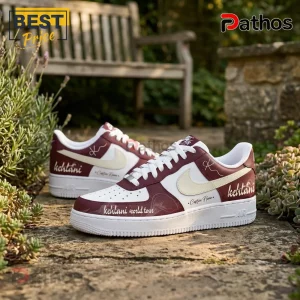 Kehlani World Tour 2026 Burgundy Custom Air Force 1 Sneakers 2 Custom maroon and white sneakers with Kehlani World Tour text and logo graphics on a stone pathway!