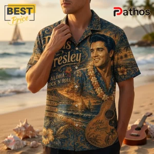 Man wearing a blue short-sleeve shirt with Elvis Presley portrait, tropical landscape, guitar, and floral patterns.!