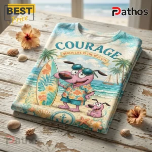 Courage the Cowardly Dog graphic t-shirt featuring a pink dog with surfboard and beach scenery on white wooden table.!