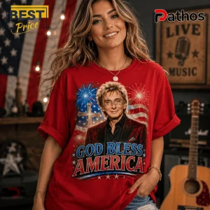 Woman wearing a red t-shirt featuring Rod Stewart, a cross, fireworks, and the text God Bless America.!