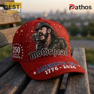 Red baseball cap featuring Lemmy Kilmister from Motörhead, vintage microphone, and America 250 text on a wooden bench.!