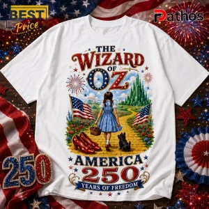 The Wizard of Oz Bless America 1776-2026 Patriotic T-Shirt 1 White graphic t-shirt featuring Dorothy from The Wizard of Oz, Toto, American flags, and text reading America 250 Years.!