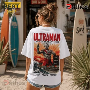 White oversized t-shirt featuring a back graphic of Ultraman, sunburst background, city skyline, and text light power protect.!