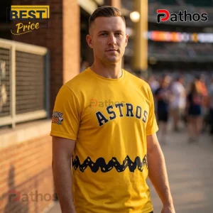 Snoopy x Houston Astros MLB Peanuts Night Collectible T-Shirt 1 Man wearing a yellow Houston Astros t-shirt with Charlie Brown zigzag pattern at the waist and Snoopy logo on the sleeve.!