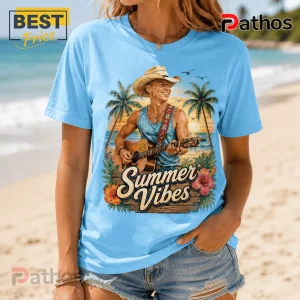Light blue t-shirt with a cowboy playing acoustic guitar on a beach with palm trees and Summer Vibes text printed on front.!