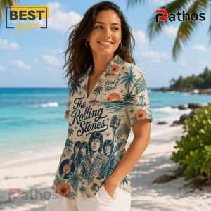 Woman wearing a beige Rolling Stones Hawaiian shirt with band members, a guitar, microphone, and tropical palm tree print.!