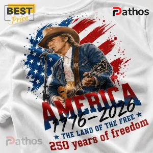 White t-shirt graphic featuring a blonde country singer in a cowboy hat and denim jacket playing guitar over a US flag.!