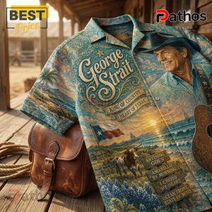George Strait button-down shirt featuring Texas landscape, longhorn, flag, guitar, and song titles on a blue floral print.!
