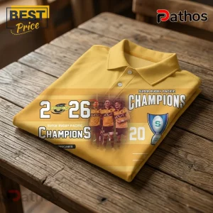 Yellow polo shirt featuring Hurricanes rugby team graphic, 2026 championship text, players, and a trophy on wood table.!