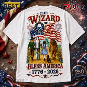 The Wizard of Oz Bless America 1776-2026 Patriotic T-Shirt 2 White t-shirt featuring The Wizard of Oz characters, American flag, yellow brick road, and text Bless America 1776-2026.!
