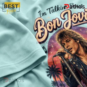 Bon Jovi Retro Roadside Nights Road Trip Vibes T-Shirt 5 Light blue t-shirt featuring a retro 80s illustration of Jon Bon Jovi singing with palm trees and a sunset background.!