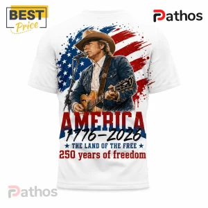 White t-shirt featuring a cowboy singer, American flag splash art, and text reading America 1776-2026 250 years of freedom.!