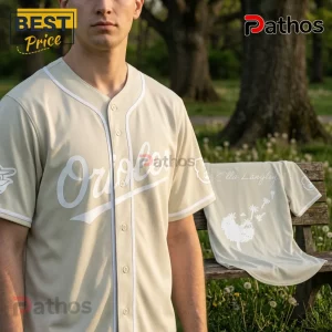 Baltimore Orioles x Ella Langley Limited Edition Baseball Jersey 2 Tan button-up baseball jersey with white Orioles lettering, worn by a man, featuring a dandelion design on the back.!