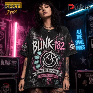 Blink-182 All The Small Things Band Merch Black Shirt 3 Woman wearing oversized acid-wash black Blink-182 graphic tee with pink smiley logo and pop-punk text in a neon setting.!