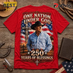 Red graphic t-shirt featuring a cowboy, American flag, cross, and the text One Nation Under God, 250 Years Of Blessings.!