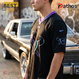 Man wearing a black Houston Texans H-Town jersey with blue and purple logo details and a classic car background.!