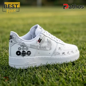 Custom white Nike Air Force 1 sneaker featuring black BTS logo, member signatures, and abstract line art on grass background.!