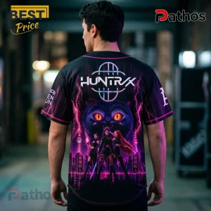 Oakland Athletics Kpop Demon Hunters Night Black Baseball Jersey 3 Back view of a black baseball jersey with HUNTRAX branding, pink lightning, a cat head, and anime characters in city scape.!
