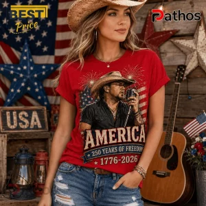 Jason Aldean America 250 Years 1776-2026 Patriotic Concert T-Shirt 4 Woman wearing red graphic t-shirt with cowboy singer, US flag, fireworks, and text America 250 Years of Freedom 1776-2026.!