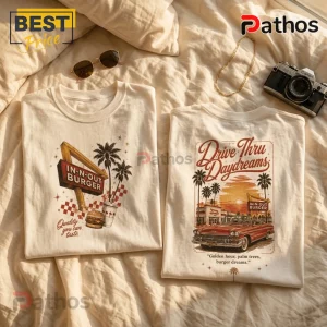 Two cream-colored t-shirts featuring vintage In-N-Out Burger graphics, palm trees, a classic car, and sunset illustrations.!