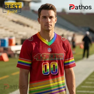 San Francisco 49ers x LGBTQ Pride Limited Edition Football Jersey 1 Man wearing red San Francisco 49ers jersey with rainbow collar, sleeve stripes, 00 number, and NFL logo on field background.!