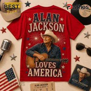 Red Alan Jackson graphic t-shirt featuring a cowboy hat, acoustic guitar, fireworks, and text reading Loves America.!