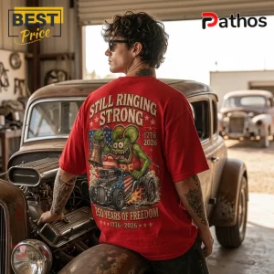 Man wearing red t-shirt with Rat Fink character, hot rod car, Liberty Bell, American flag, and 1776-2026 printed on back.!