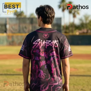 Man wearing black and pink K-pop Saja Boys graphic baseball jersey with anime-style characters on a baseball field background.!