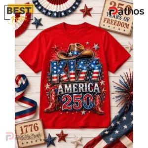 Red cotton crewneck t-shirt featuring graphic text KISS AMERICA 250, cowboy hat, boots, and stars on a wooden background.!