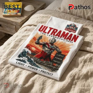 White cotton t-shirt featuring Ultraman illustration, sunset, waves, city skyline, and text Ultraman The Legendary Hero.!