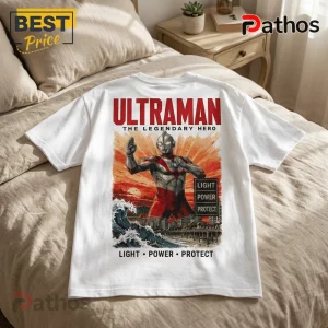 White cotton t-shirt featuring a vintage-style Ultraman illustration, sunset, ocean wave, and text reading Light Power Protect.!