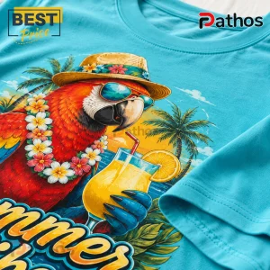 Cyan cotton t-shirt with a graphic of a macaw wearing a straw hat, sunglasses, and floral lei, holding a fruit cocktail.!