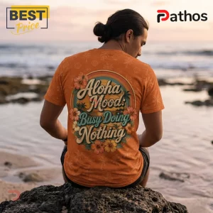 Man wearing an orange t-shirt with tropical hibiscus flowers and text Aloha Mood: Busy Doing Nothing printed on the back.!