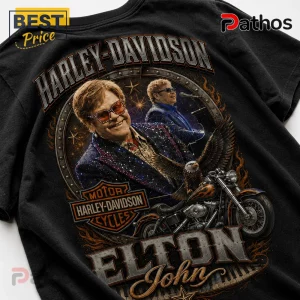 Black t-shirt featuring Elton John, Harley-Davidson logo, eagle, flames, and piano keys in a circular frame graphic.!