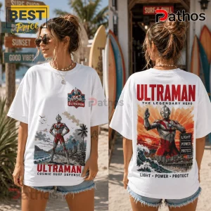 White cotton t-shirt featuring Ultraman graphics, with chest logo and large back print of Ultraman on a beach at sunset.!