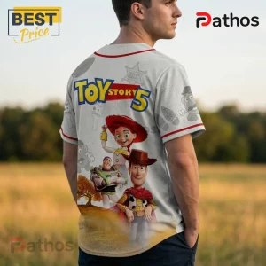Toy Story 5 baseball jersey featuring Woody, Buzz Lightyear, and Jessie on a heathered grey fabric with red trim.!