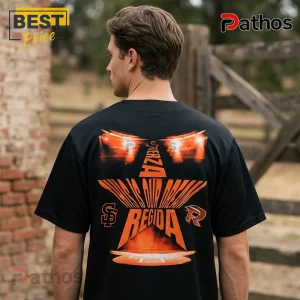 Fuerza Regida x San Francisco Giants This Is Our Dream 2026 Baseball Jersey 3 Man wearing a black t-shirt with orange graphic featuring a star, car headlights, and Fuerza Regida text on the back.!