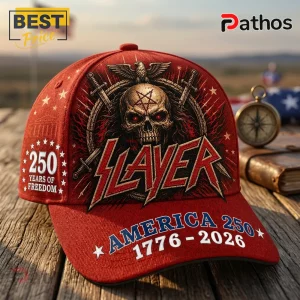 Slayer x America 250 Years 1776-2026 Anniversary Edition Baseball Cap 2 Red baseball cap featuring Slayer band logo, a skull, eagle, swords, and America 250 1776-2026 text on a wooden surface.!