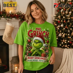 Bright green crewneck t-shirt featuring The Grinch wearing a Santa hat, surrounded by gifts and candy canes with text.!