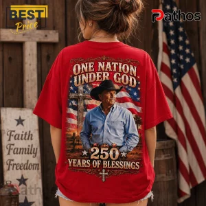 Red graphic t-shirt featuring a man in a cowboy hat, US flag, wooden cross, and text: One Nation Under God 250 Years.!