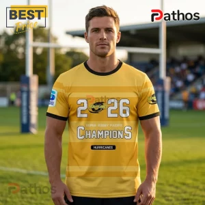 Man wearing yellow rugby jersey with 2026 Hurricanes Super Rugby Pacific Champions text and logo on a field background.!