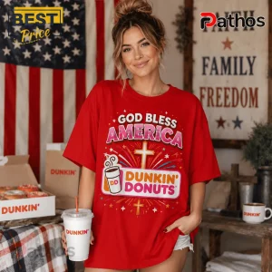 Woman wearing a red t-shirt with Dunkin Donuts logo, a cross, and God Bless America text, holding a Dunkin coffee cup.!