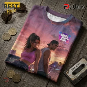 GTA VI graphic t-shirt featuring a man and woman against a sunset city backdrop on a dark wooden surface with a cassette.!