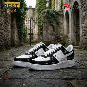 Black and white leather sneakers with Evanescence band logos and signatures, white laces, and rubber soles on stone path.!