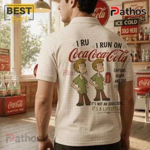 Man wearing a cream checkered polo shirt with Shaggy from Scooby-Doo holding a Coca-Cola and vintage soda brand text.!