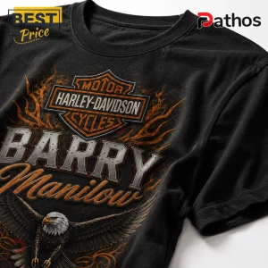 Black cotton t-shirt featuring a Harley-Davidson logo, orange flames, an eagle graphic, and text reading Barry Manilow.!