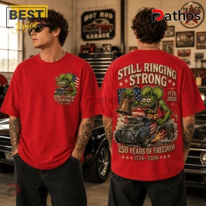 Red graphic t-shirt featuring a green cartoon rat driving a hot rod with an American flag and Liberty Bell illustration.!